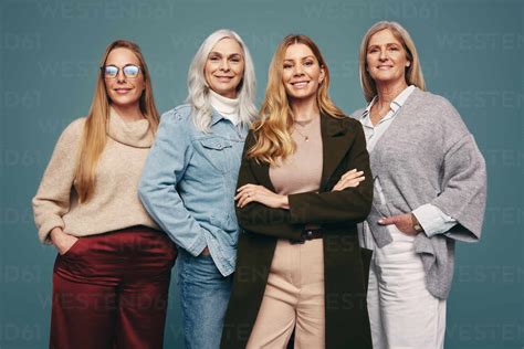 Smiling mature women standing together in a studio. Group of four ...
