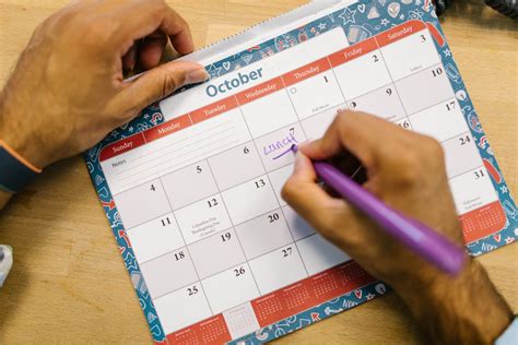 Person Writing on a Calendar · Free Stock Photo