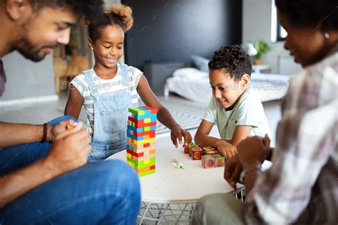 Happy family playing and having fun together at home Stock Photo by nd3000